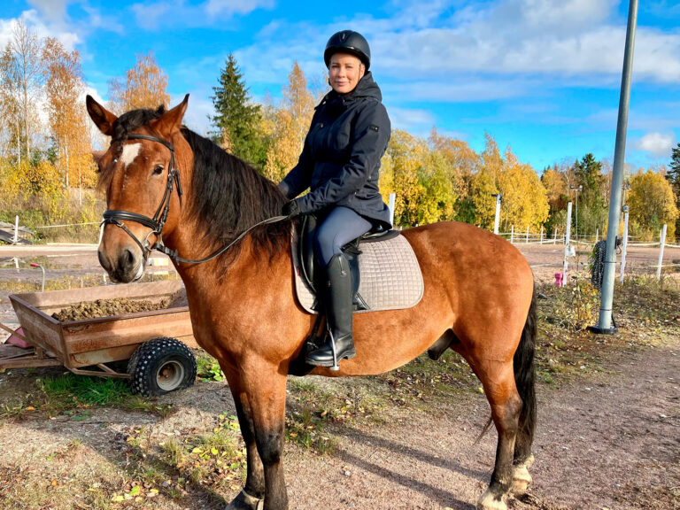 Nainen hevosen selässä.