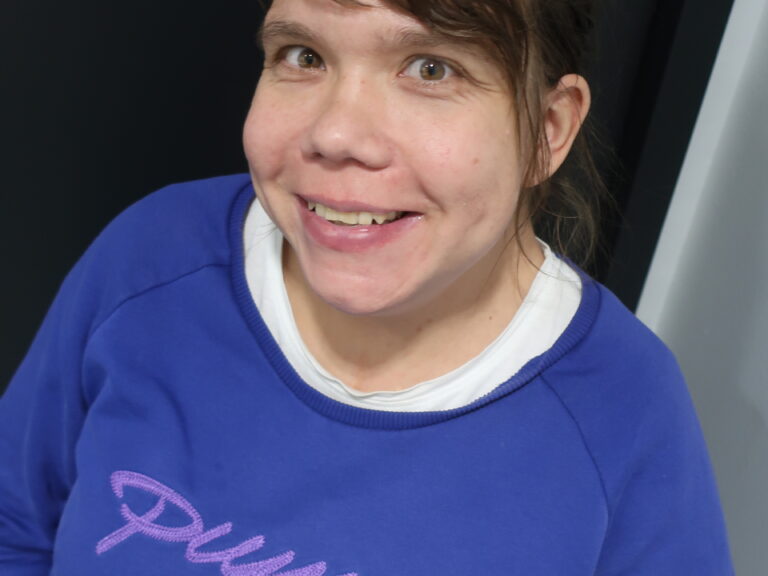 Nainen sinisessä Puma-merkkisessä paidassa.