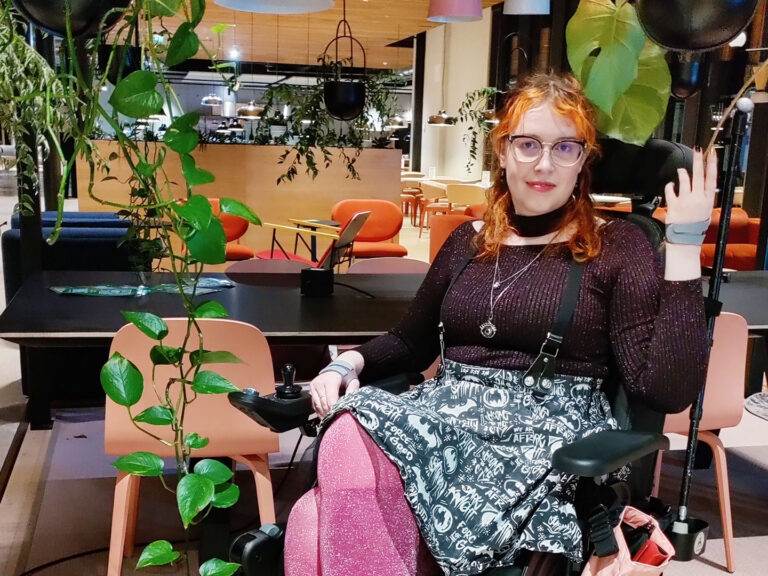 Oona Tontti pyörätuolissaan ravintolamiljöössä