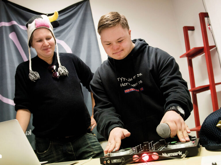 Nainen ja nuori poika dj-pöydän takana.