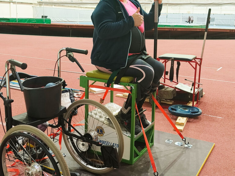 Elina Miettinen istuu heittotuolissaan urheiluhallissa.